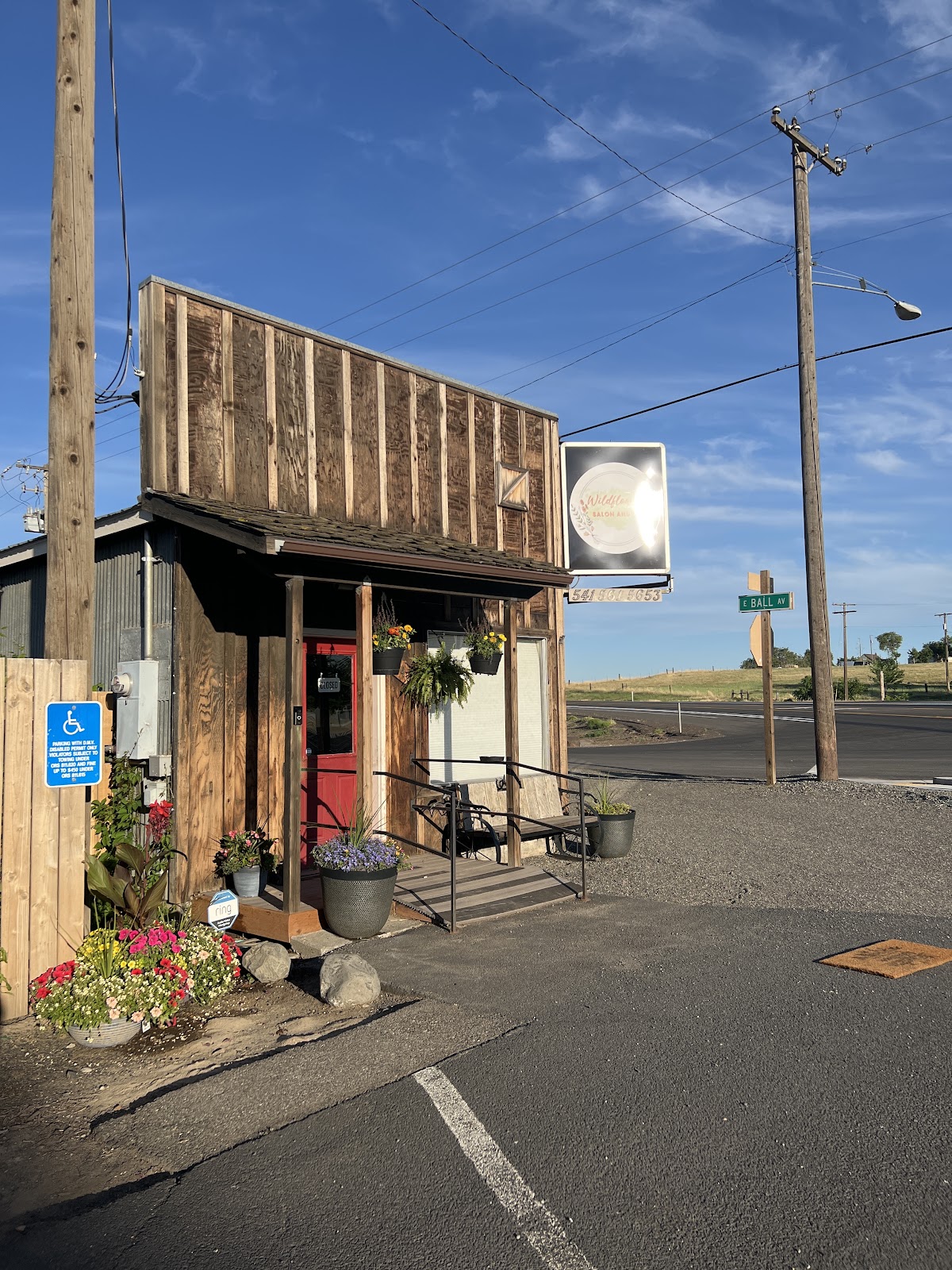 The Wildflower Salon and Spa storefront, a reclaimed-wood building with a red door and flower beds